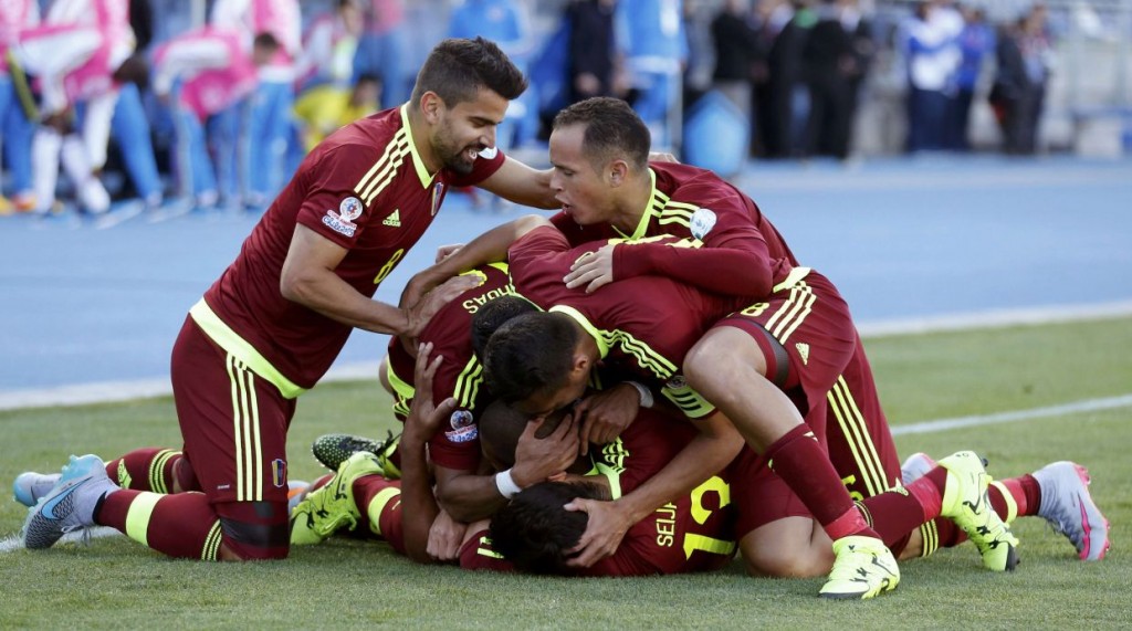 Venezuela players mob teammate Jose Rondon as they celebrate his goal against Colombia during their first round Copa America 2015 soccer match at Estadio El Teniente in Rancagua